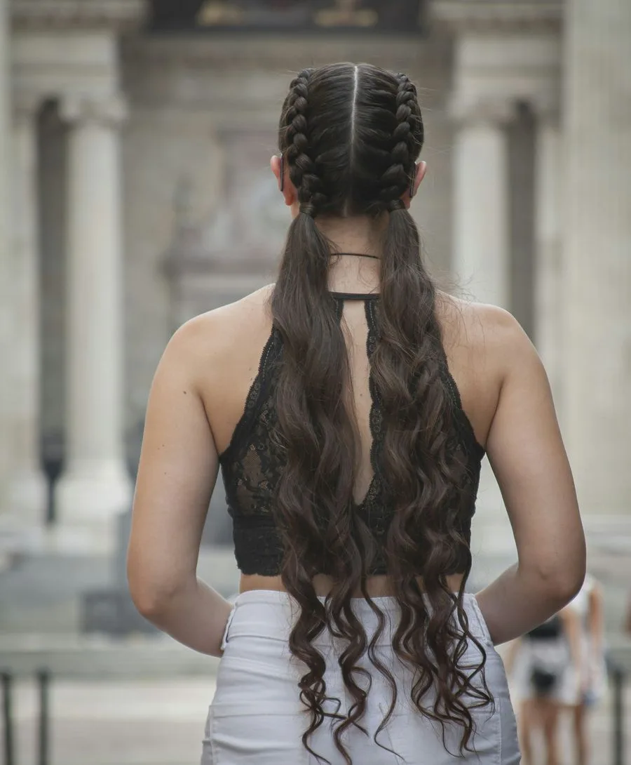 Lunghi capelli mossi raccolti in due trecce, vista di spalle